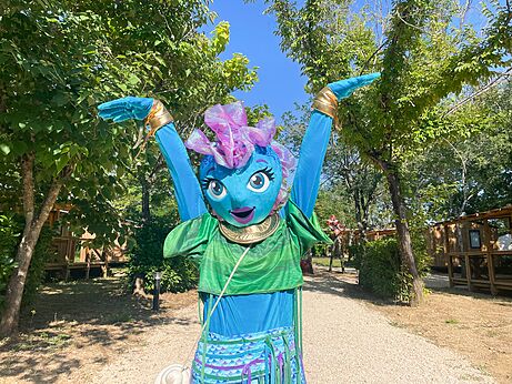 Mascota de camping sonriente con brazos levantados para animación en el camping VAGUES OCEANES Près de la Fontaine à Gouaix (77).
