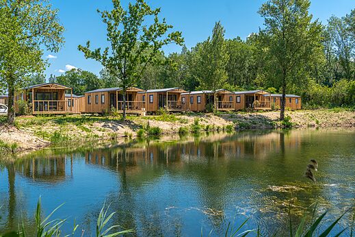 Mobil-homes de madera junto a un estanque, en el camping VAGUES OCEANES Près de la Fontaine à Gouaix (77).