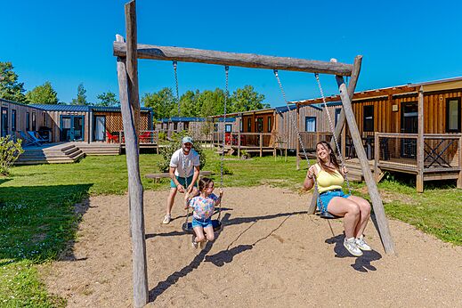 Juegos, familia feliz en los columpios al camping VAGUES OCEANES Près de la Fontaine à Gouaix (77).