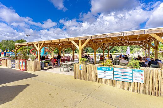 Terraza de restaurante y juegos infantiles en camping VAGUES OCEANES en Gouaix.