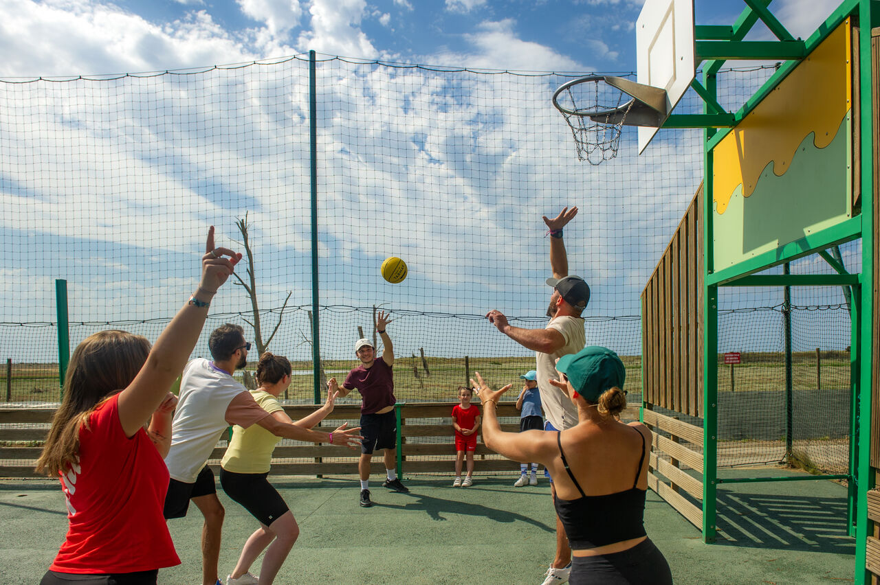 Familia jugando baloncesto en cancha multideporte en el camping CAPFUN Prises en La TRANCHE SUR MER (85).