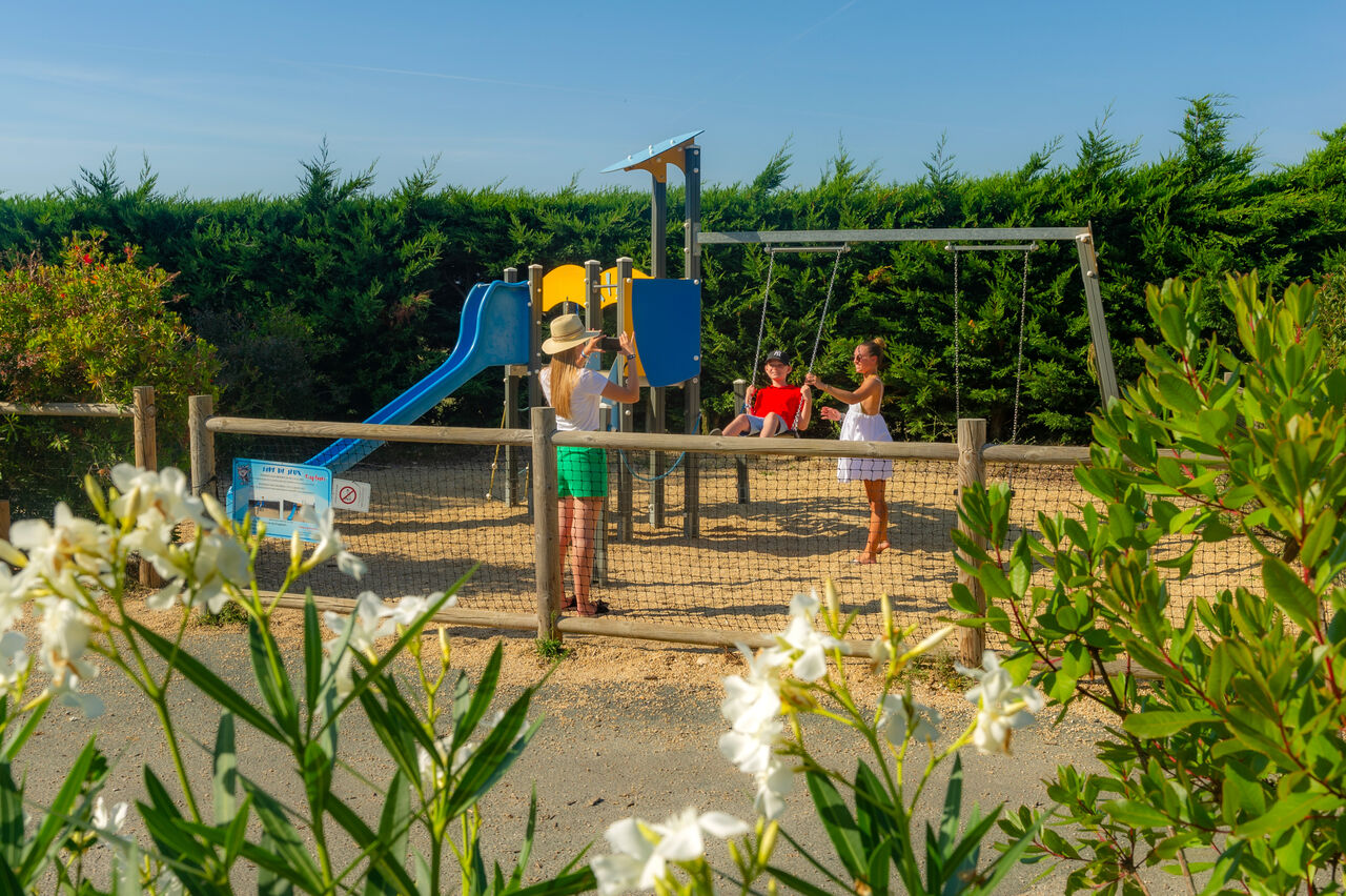 Zona de juegos con tobog�n y columpios en el camping CAPFUN Prises en La TRANCHE SUR MER (85).