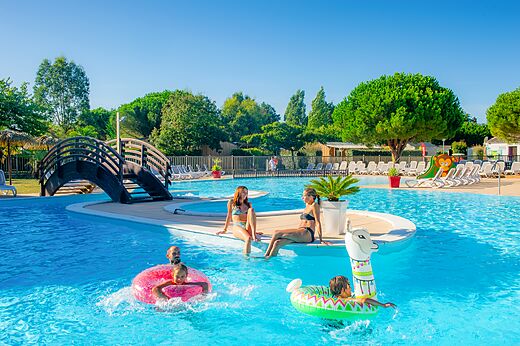 Piscina exterior con puente en el camping CAPFUN Quatre Vents d'Oléron.