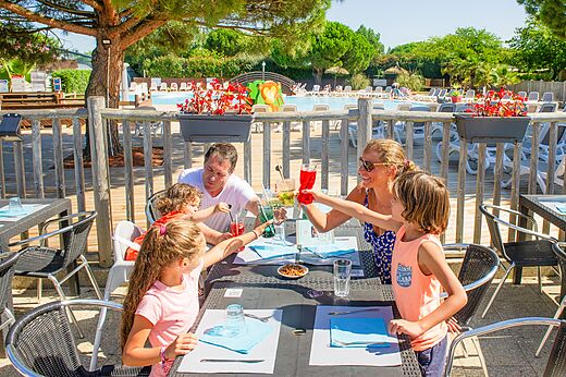 Familia brindando en el restaurante exterior del camping CAPFUN Quatre Vents d'Ol�ron.