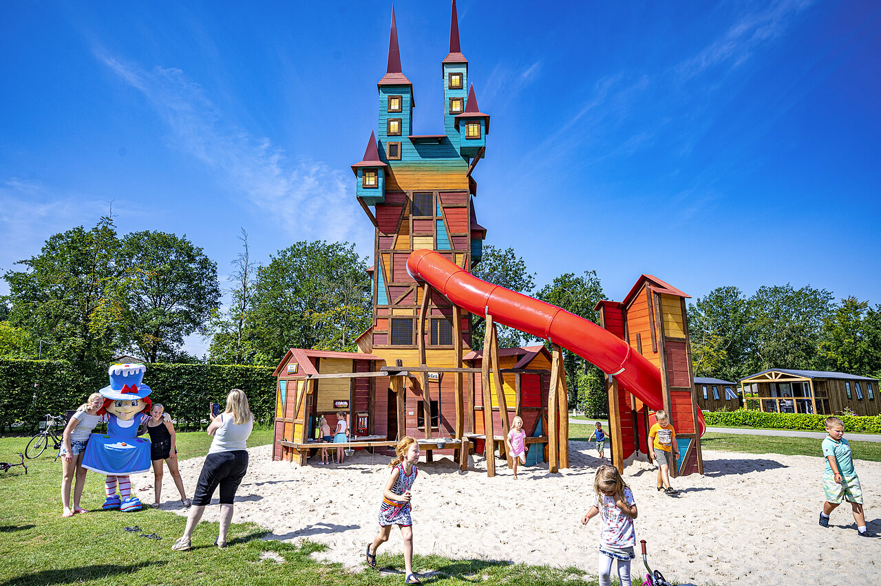 Castillo de juegos colorido con tobog�n y ni�os en el camping CAPFUN Rakelbos en Westelbeers.