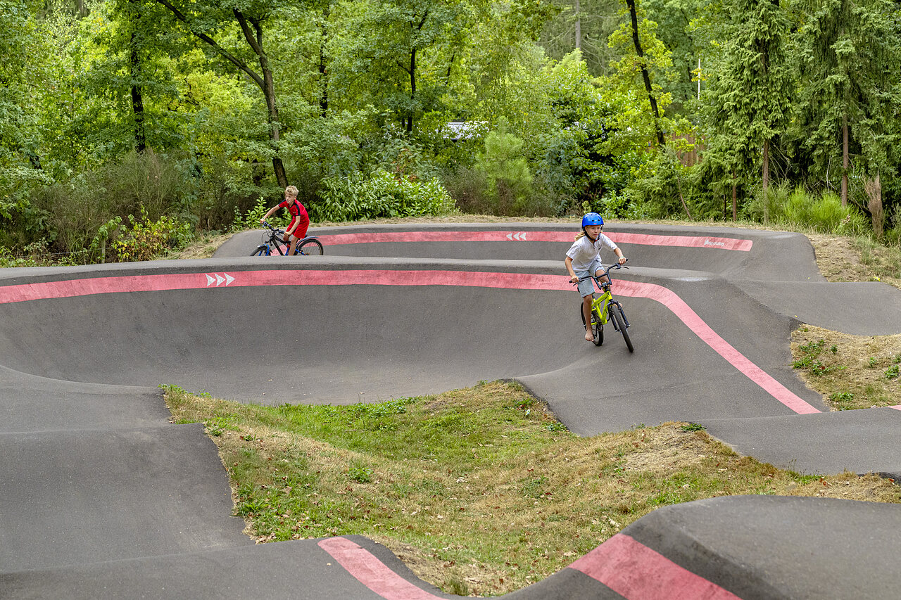 Ni�os en bicicleta en pista de pump track en camping CAPFUN Rakelbos, Westelbeers.