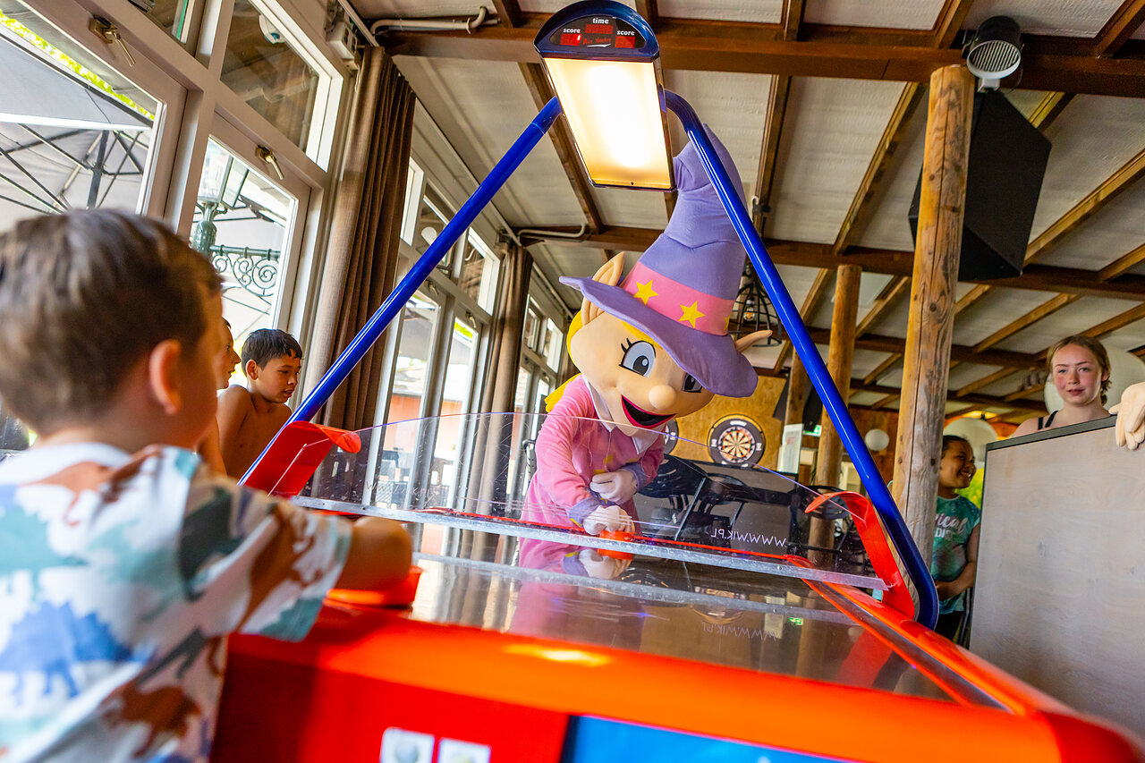 Mascota y ni�os jugando al air hockey en el camping CAPFUN Rakelbos en Westelbeers.