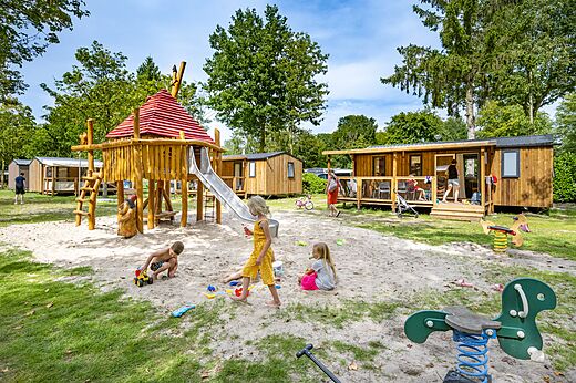 Parque infantil de madera con tobog�n y ni�os en el camping CAPFUN Rakelbos en Westelbeers.