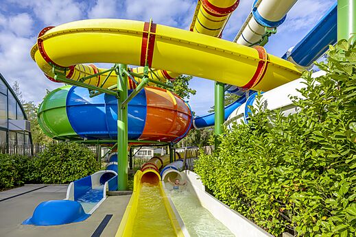 Toboganes acu�ticos coloridos y piscina exterior en el camping CAPFUN Rakelbos en Westelbeers.
