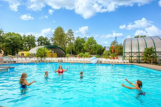 Familia divirtiéndose en la gran piscina exterior soleada en el camping CAPFUN Rakelbos en Westelbeers.