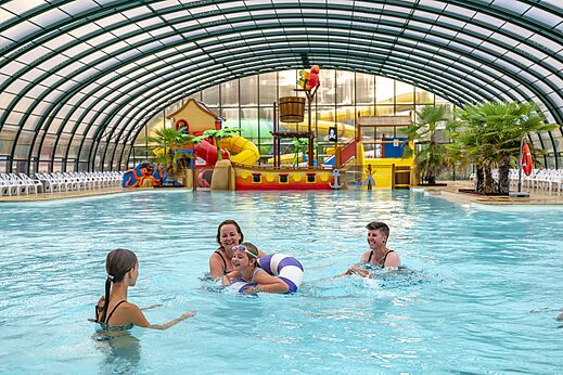 Piscina cubierta, juegos acuáticos, familia en el camping CAPFUN Rakelbos en Westelbeers.