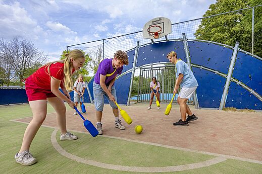 J�venes jugando al hockey en una cancha multideportiva en el camping CAPFUN Rakelbos en Westelbeers.