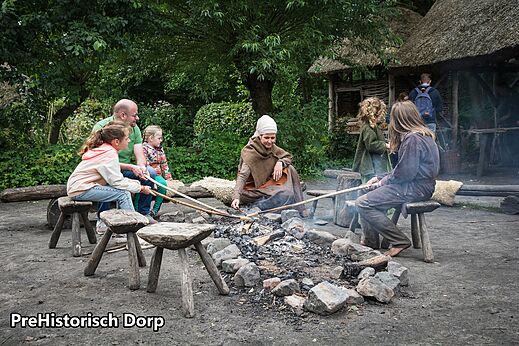 Pueblo prehist�rico con visitantes cocinando en fuego de le�a cerca de Eindhoven.