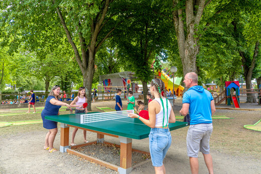 Familia jugando al tenis de mesa al aire libre en camping CAPFUN Ranch des Volcans (63).