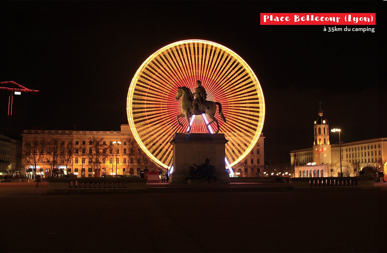 Plaza Bellecour en Lyon de noche, noria y estatua ecuestre iluminadas.