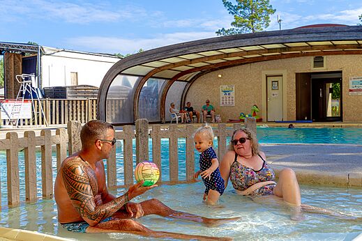 Familia con bebé jugando en la piscina cubierta del camping CAPFUN Régnière en VILLETTE D'ANTHON (38).