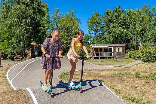 Niños divirtiéndose en la pista de patinetes del camping CAPFUN Régnière en VILLETTE D'ANTHON.