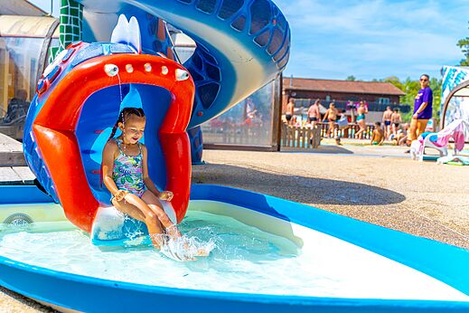 Tobogán acuático colorido, niña jugando en el camping CAPFUN Régnière en VILLETTE D'ANTHON (38).