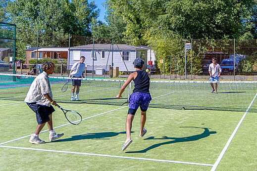 Partido de tenis en la cancha multideporte del camping CAPFUN Régnière en VILLETTE D'ANTHON.