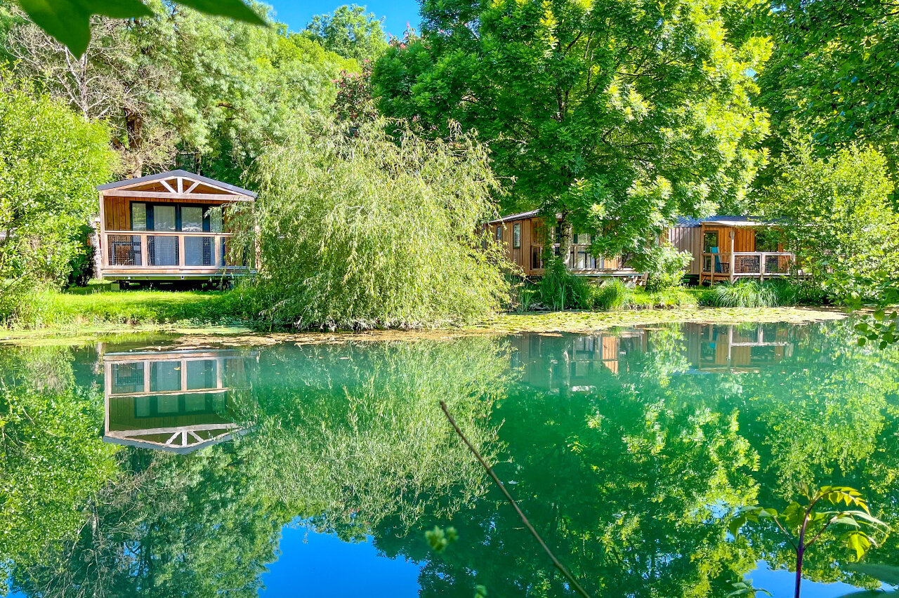 Mobil-homes de madera junto a un estanque, naturaleza en el camping CAPFUN La Rivi�re en Valence-en-Poitou (86).