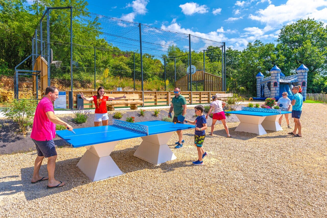 Familias jugando al ping-pong, cancha multideporte, castillo hinchable en el camping CAPFUN La Rivi�re en Valence-en-Poitou (86).