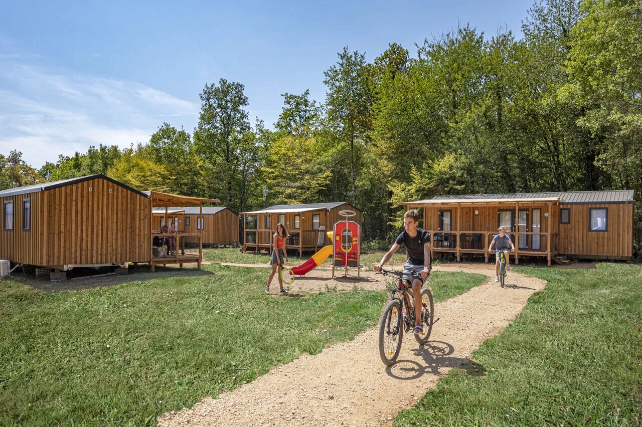 Mobil-homes, zona de juegos, ni�os en bicicleta en el camping CAPFUN La Rivi�re en Valence-en-Poitou.