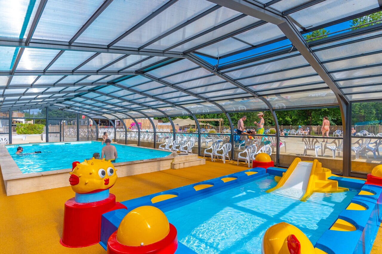 Piscina cubierta con tobog�n y piscina infantil en camping CAPFUN La Rivi�re en Valence-en-Poitou (86).