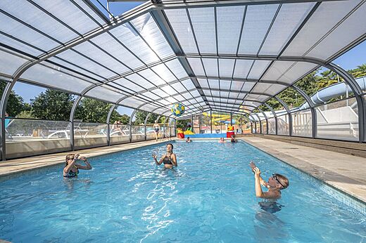 Piscina cubierta con ni�os, toboganes, en el camping CAPFUN La Rivi�re en Valence-en-Poitou (86).