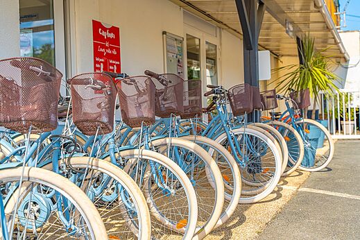 Bicicletas de alquiler azules con cestas alineadas en el camping CAPFUN La Rivi�re en Valence-en-Poitou (86).