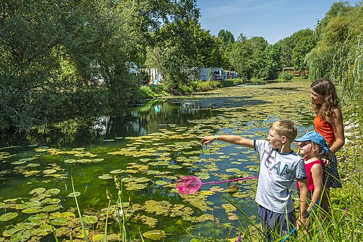 Familia y ni�os pescando en el r�o natural del camping CAPFUN La Rivi�re en Valence-en-Poitou.
