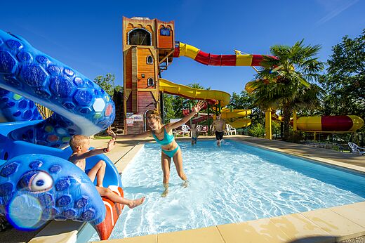 Piscina exterior con toboganes acuáticos y estructura pirata en CAPFUN Roca d'Amour.
