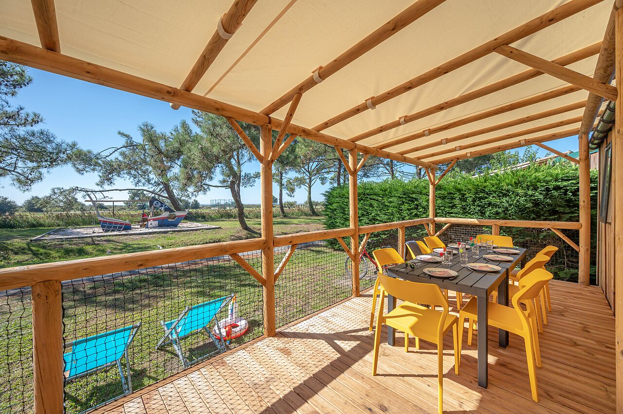 Terraza Mobil-home, mesa, sillas, juegos en el camping CAPFUN Roumingue en LANTON (33).