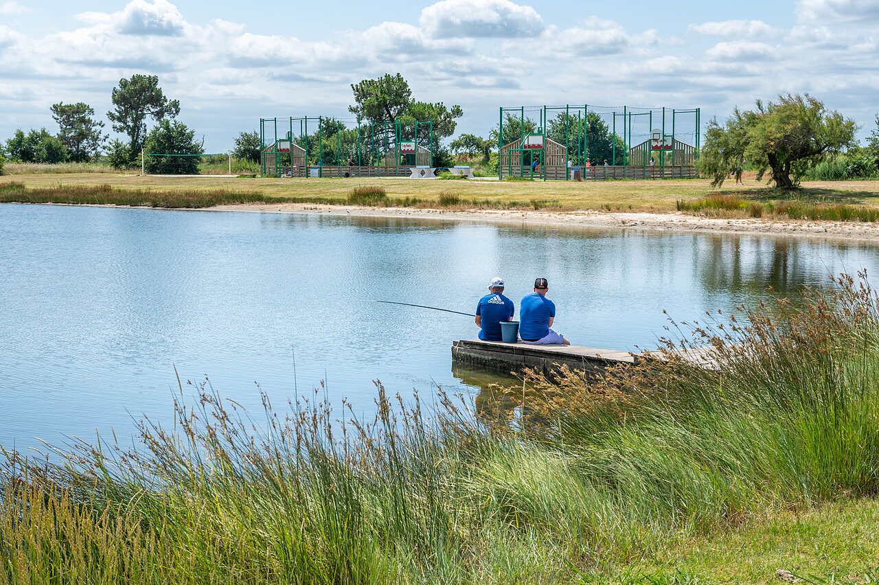 Pescadores en el lago, campos deportivos en el camping CAPFUN Roumingue en LANTON (33).