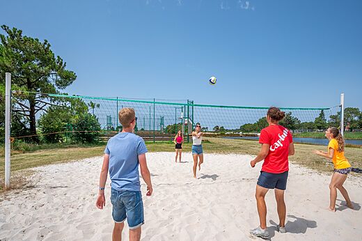Jóvenes jugando voleibol playa en camping CAPFUN Roumingue en LANTON (33).