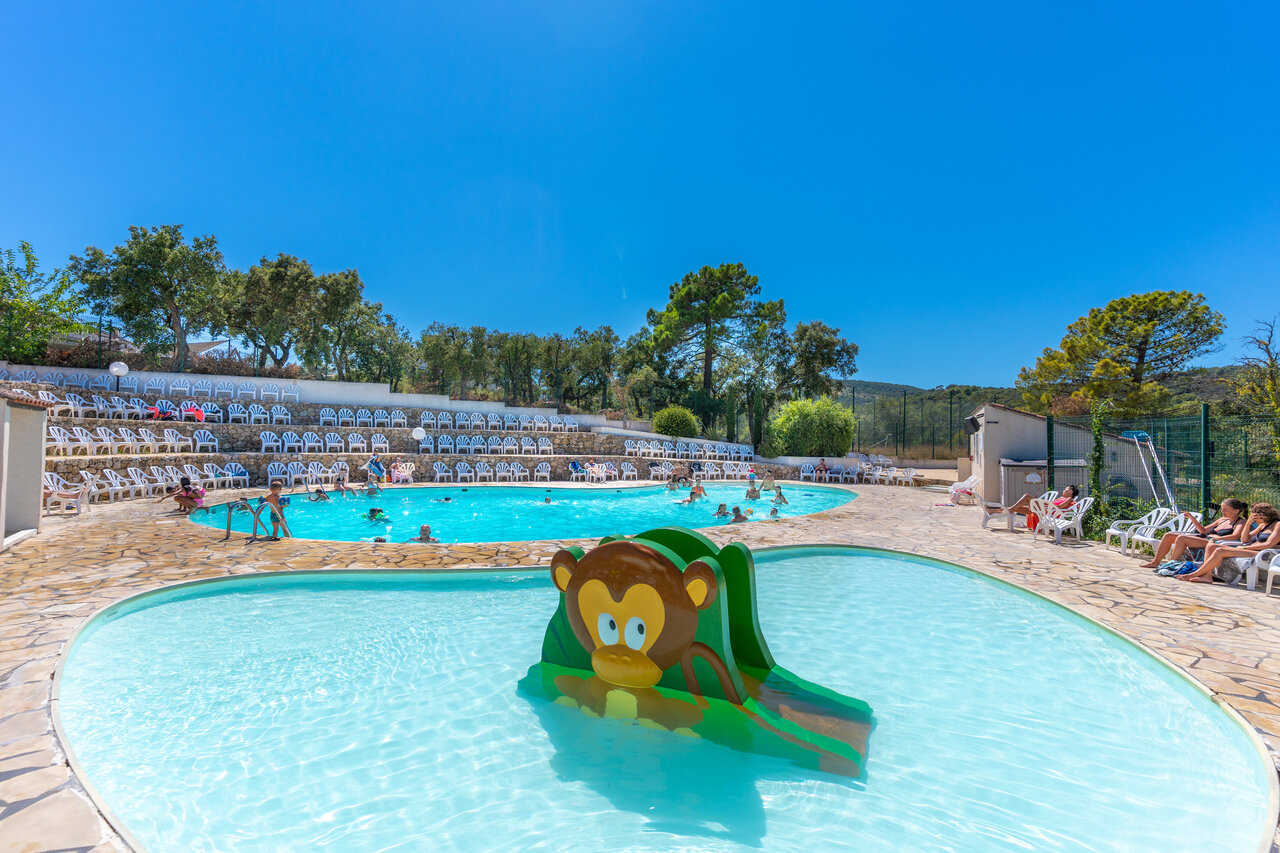 Piscina exterior, tobog�n infantil, gradas en el camping CAPFUN La Rumba en Fr�jus (83).