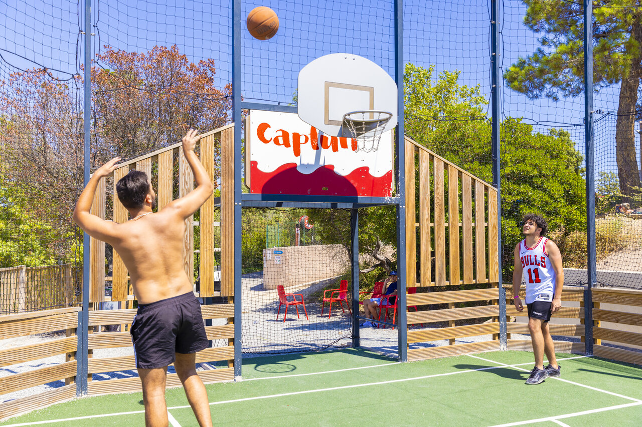 Cancha multideportiva con j�venes jugando baloncesto en el camping CAPFUN La Rumba en Fr�jus.