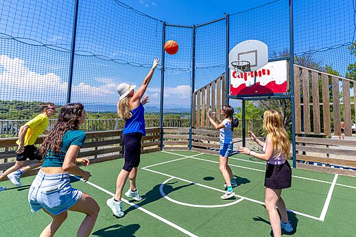 Familia jugando baloncesto en la cancha multideporte del camping CAPFUN La Rumba en Fr�jus (83).