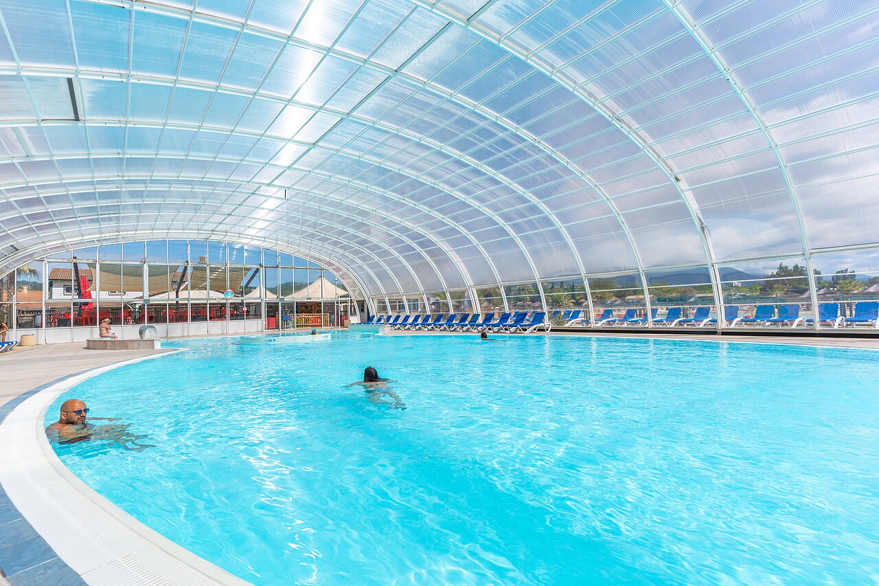 Piscina cubierta, ba�istas y tumbonas, camping CAPFUN Sagittaire en VINSOBRES (26).