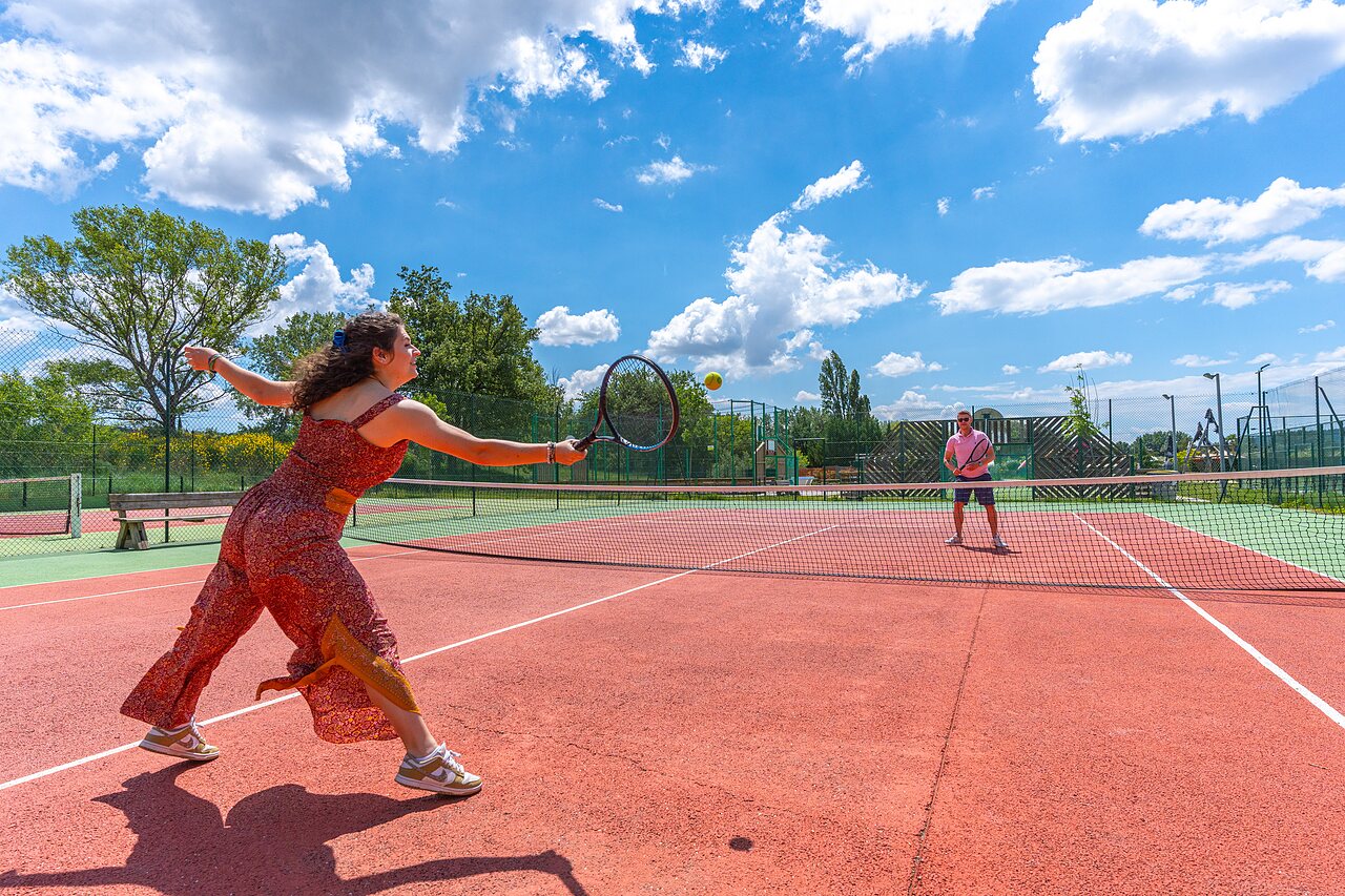 Jugadores de tenis en cancha exterior del camping CAPFUN Sagittaire en VINSOBRES (26).