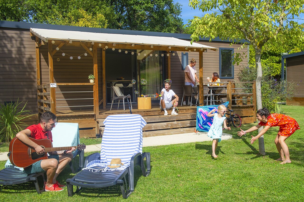 Familia en Mobil-home con terraza en el camping CAPFUN Sagittaire en VINSOBRES (26).
