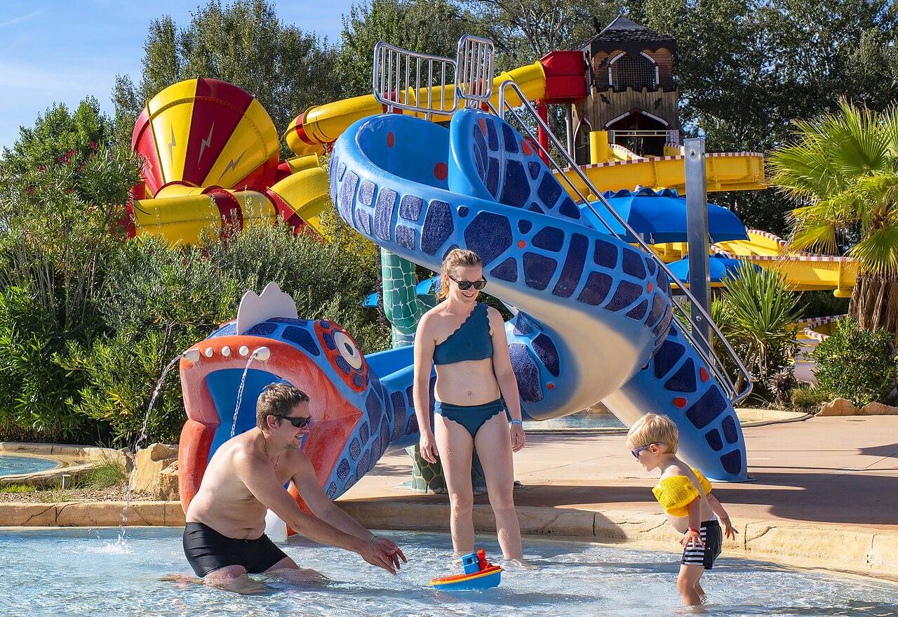 Familia disfrutando de toboganes y piscina en el camping CAPFUN Sagittaire en VINSOBRES (26).