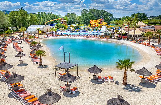 Piscina laguna, playa de arena y sillas en el camping CAPFUN Sagittaire en VINSOBRES (26).