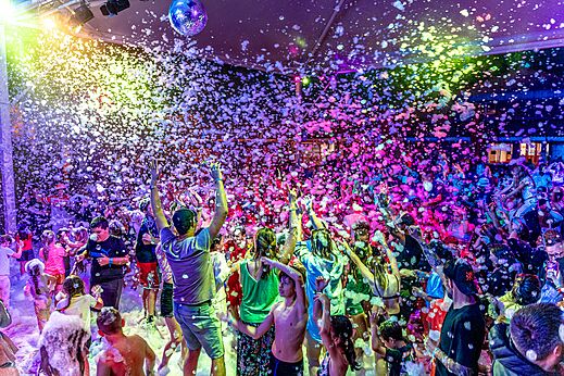 Fiesta de la espuma animada con campistas bajo luces de colores en el camping CAPFUN Sagittaire en VINSOBRES (26).