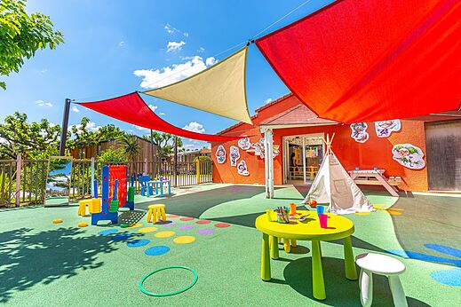 Zona de juegos exterior colorida con mesas y juegos para ni�os en el camping CAPFUN Sagittaire en VINSOBRES (26).