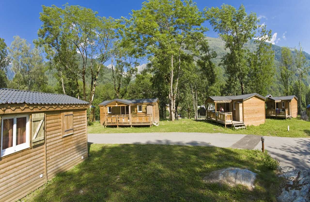 Mobil-homes de madera con terrazas, rodeados de �rboles en el camping CAPFUN Saint Colomban.
