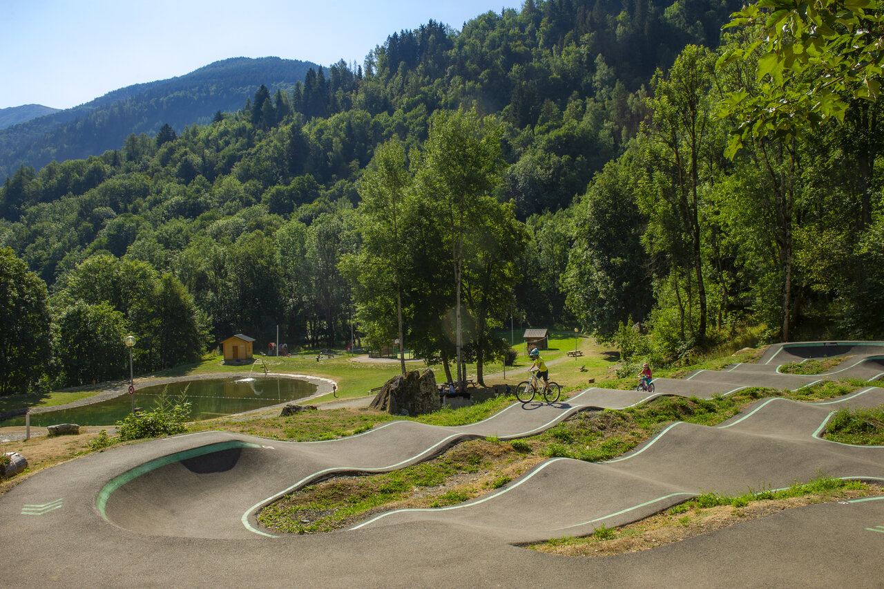 Pumptrack y ni�os en bicicleta cerca del lago en camping CAPFUN Saint Colomban.