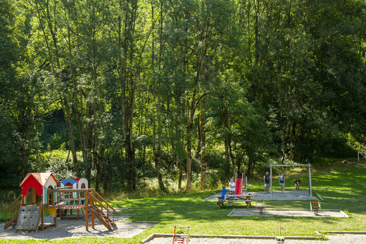 Zona de juegos infantiles con estructura, toboganes y columpios en el camping CAPFUN Saint Colomban.