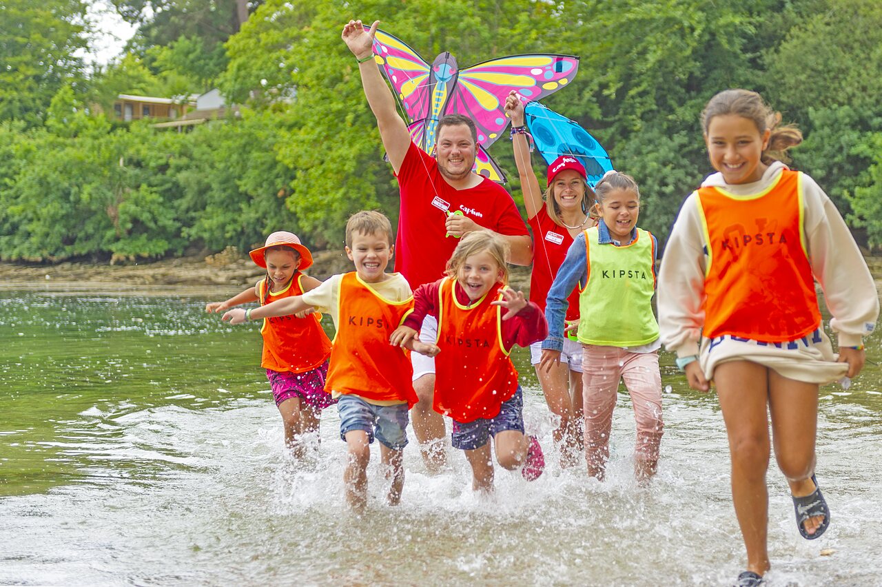 Ni�os y animadores jugando en el agua con una cometa en el camping CAPFUN Saint Laurent en LA FORET FOUESNANT (29).
