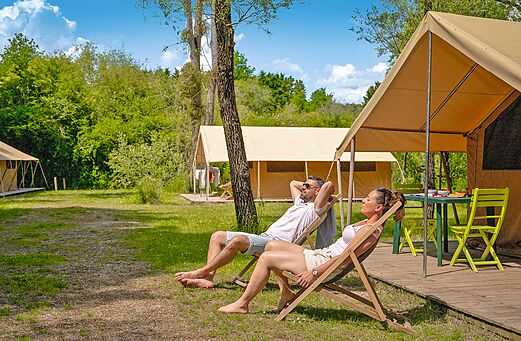 Tienda de lona espaciosa y pareja relaj�ndose en el camping CLICOCHIC Les Saules de Cheverny en Cheverny (41).