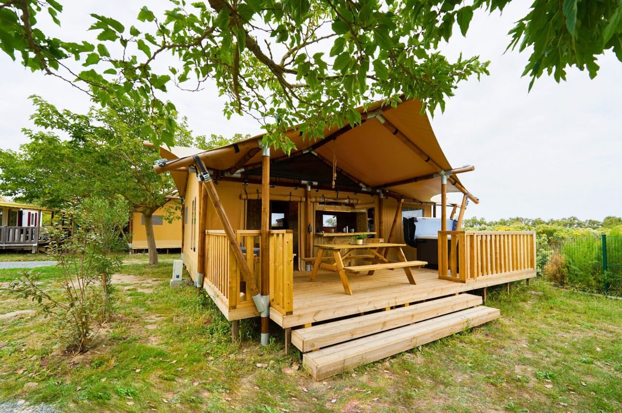 Tienda lodge con terraza de madera en el camping CLICOCHIC Seuli�res en Saint-Denis-d'Ol�ron.